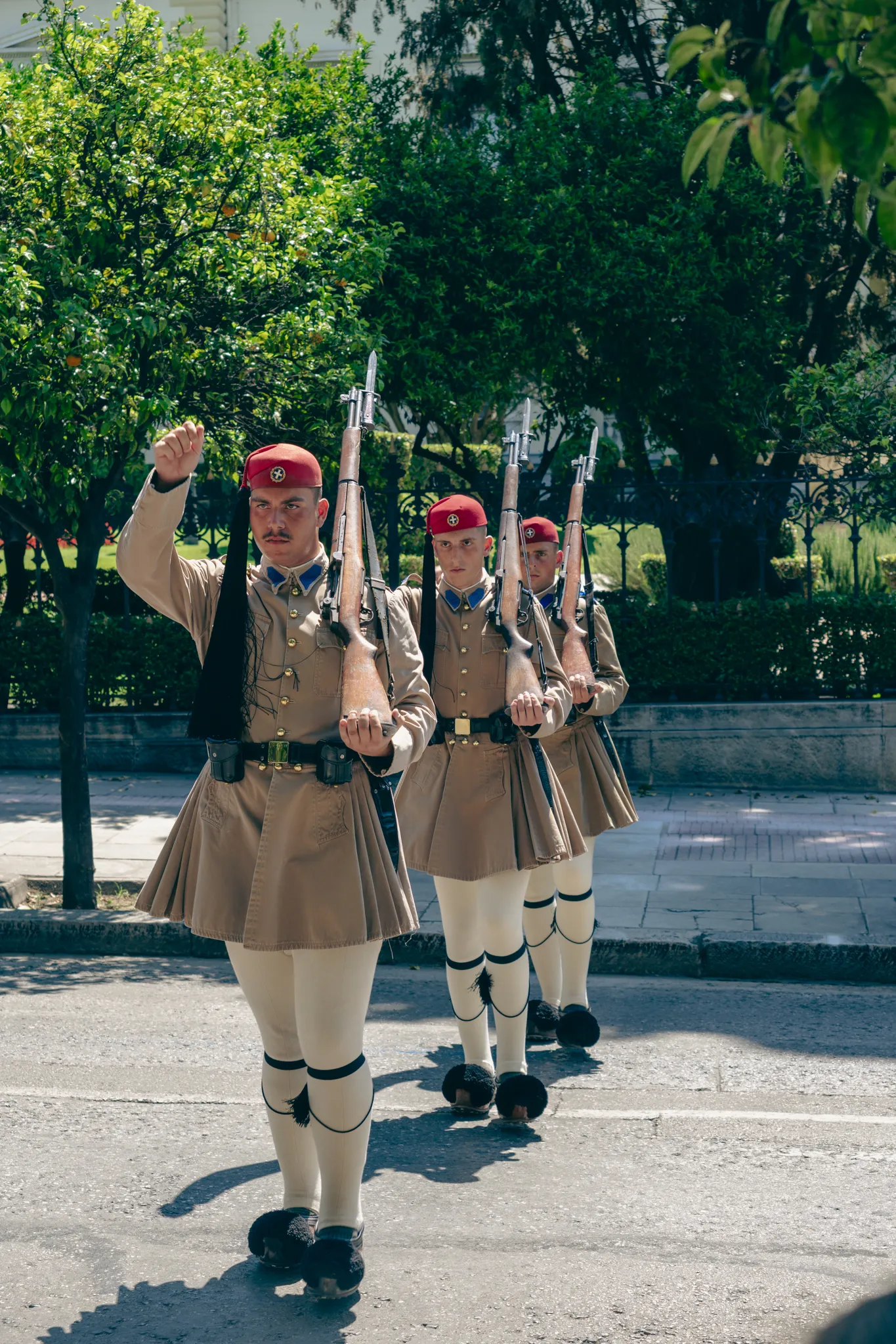 Three Evzones of the Greek presidential guard marching in step in ceremonial dress